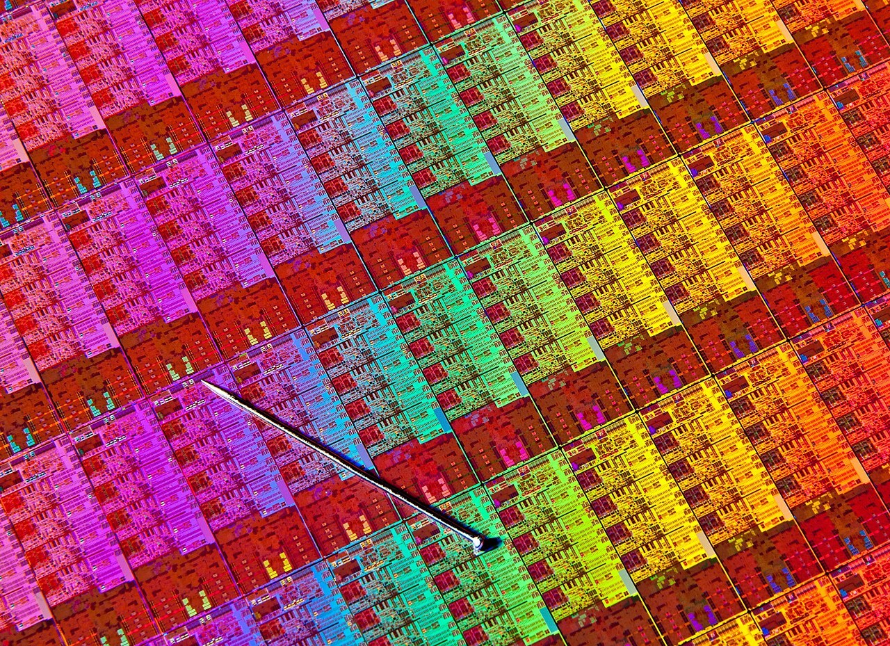 Close-up of an Intel Haswell silicon wafer with a small pin resting on its surface.