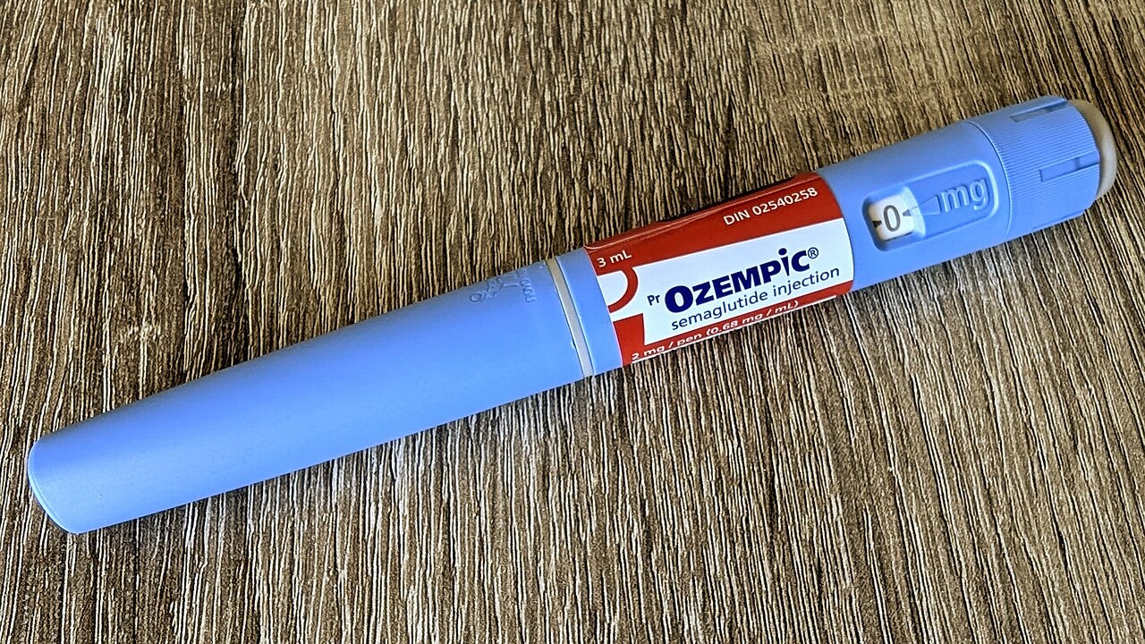 An Ozempic semaglutide injection pen with an English label on a wooden table.